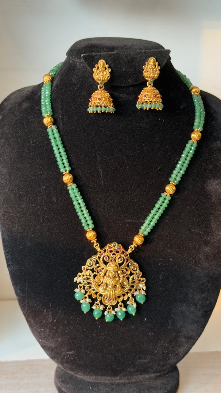 Elegant Temple Jewelry set features a double-strand necklace of mint green beads and an antique gold-finish pendant of Goddess Lakshmi.