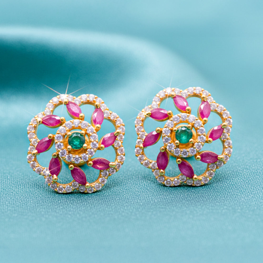 Floral stud earrings with pink and green stones.
