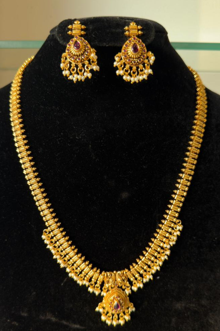 Elegant long necklace features a repeating Guttapusalu-inspired pattern of vertical gold links.
