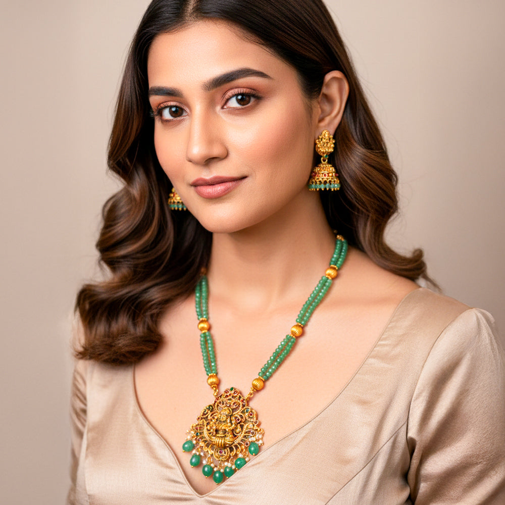 Elegant Temple Jewelry set features a double-strand necklace of mint green beads and an antique gold-finish pendant of Goddess Lakshmi.